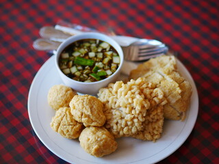 Indonesian Food empek-empek (savory fish cake dish) from Palembang, South Sumatra, Indonesia served in plate. Served in sweet and sour sauce with mashed ebi shrimp, dice cucumbers