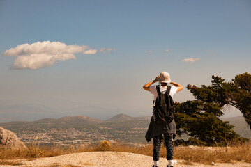 Woman watching the view with binoculars at the top of a hill.