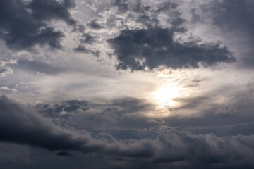 Fototapeta na wymiar Grey high layered grey epic clouds with sun and sunlight on sky. Heaven cloudscape air view