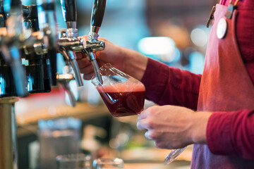 Bright metal beer tap, natural light, red beer