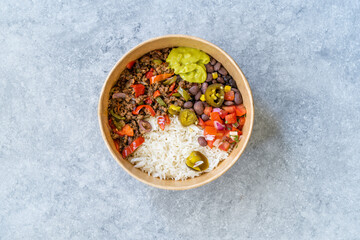 Take Away Traditional Mexican Tex-Mex Food with Minced Meat, Basmati Rice, Chicken and Guacamole Sauce in  Take Out Plastic Bowl.