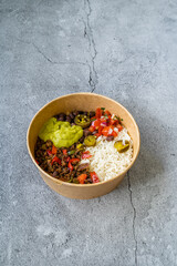 Take Away Traditional Mexican Tex-Mex Food with Minced Meat, Basmati Rice, Chicken and Guacamole Sauce in  Take Out Plastic Bowl.