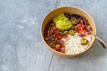 Take Away Traditional Mexican Tex-Mex Food with Minced Meat, Basmati Rice, Chicken and Guacamole Sauce in  Take Out Plastic Bowl.