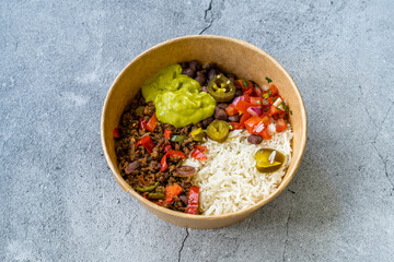 Take Away Traditional Mexican Tex-Mex Food with Minced Meat, Basmati Rice, Chicken and Guacamole Sauce in  Take Out Plastic Bowl.