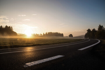 Empty morning road through foggy landscape