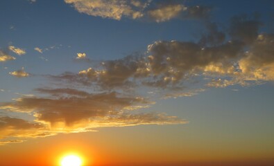 Beautiful golden sunset in the sky, sun sets over the horizon, natural background 