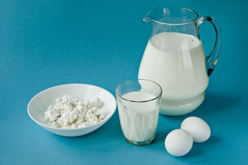 Different dairy products on the white wooden boards, blurred background