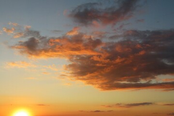 Obraz premium Beautiful fiery orange clouds in the sky at sunset, natural background