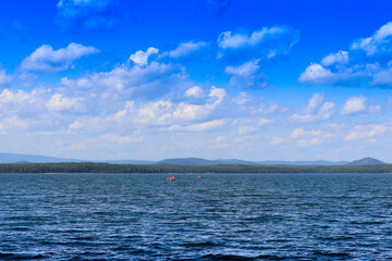 Obraz premium View of the opposite shore of the lake in the afternoon.