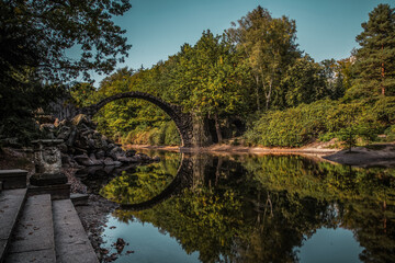 Ancient stone bridge in water reflection