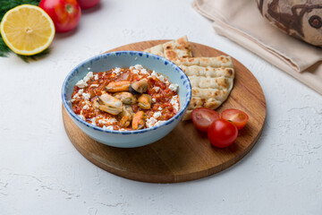 saganaki mussels Greek cuisine on white concrete table