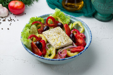 Greek salad with feta on white concrete table