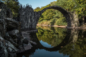 Ancient stone bridge in water reflection