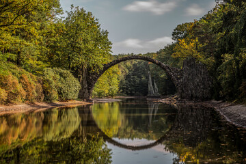 Ancient stone bridge in water reflection