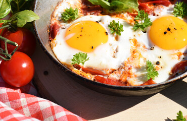 Breakfast scrambled eggs with tomatoes and herbs in nature