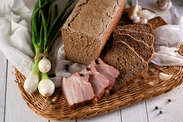 Fototapeta na wymiar homemade rye bread for breakfast fresh baked aromatic with meat products and onions on a wicker plate