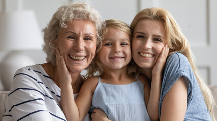 Happiness in being together. Family of three diverse age females posing for portrait, happy small...