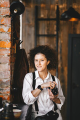 Female photographer with afro hairstyle, who poses in the city coffee shop.