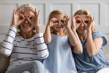 We have cute goggles. Happy funny intergenerational family of three, senior grandma, adult mom and...