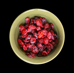 Cranberries in a bowl isolated on black background