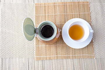 Tea strainer as a teapot for making hot drink on the table with a cup of tea.