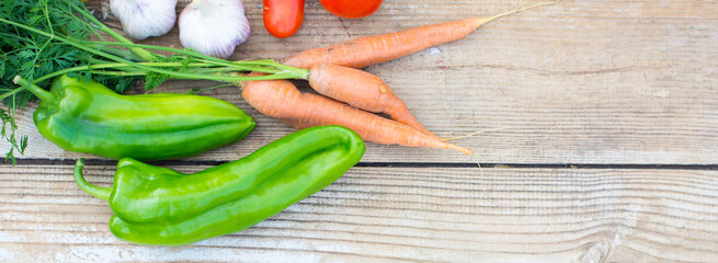 Fresh vegetables, green peppers, carrots, cooking ingredients on rustic wooden board, plant based food, healthy lifsyle harvest time