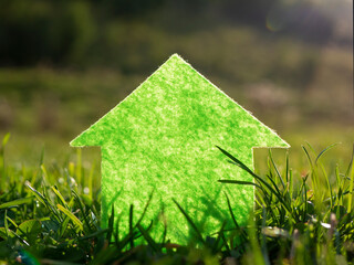 Eco house on fresh green grass in the sun. Investment, finance, mortgage concept.