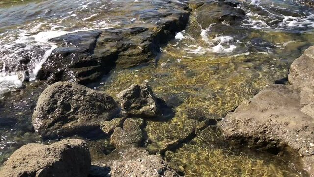 The rocky beach is washed by sea waves