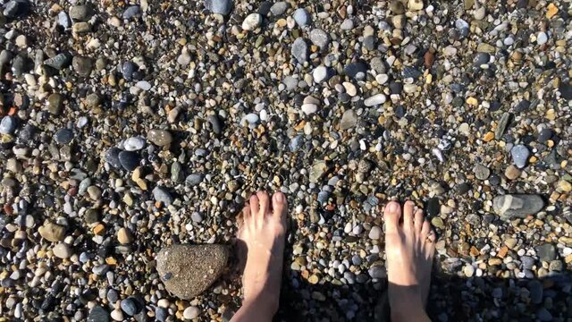 Feet on a rocky beach by the sea