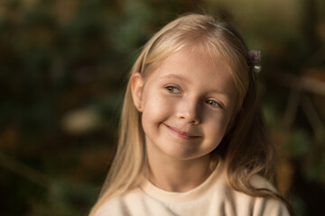 Cute stylish little girl with long blonde hair walking in autumn park. Autumn kids fashion. Happy childhood. Lifestyle portrait. Caucasian child 6 years old outdoor