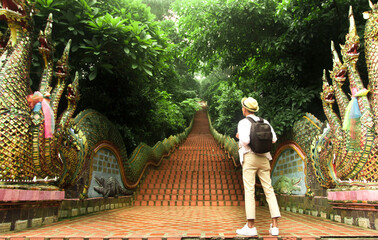 Trveler man standing at Naga stair in Wat Phra That Doi Suthep where is famous temple in Chiang Mai, Thailand