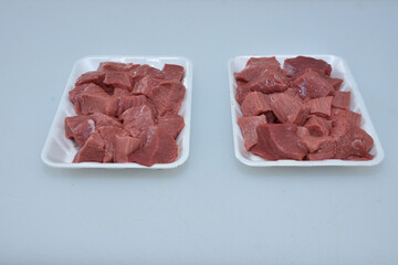 fresh boneless lamb meat chopped cubes in plates,uncooked raw mutton pieces closeup