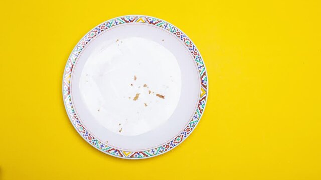 Top view hand sending banana cake of eating a layer on yellow background – 4k Stop motion.