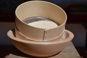 sieve for flour and wooden bowl