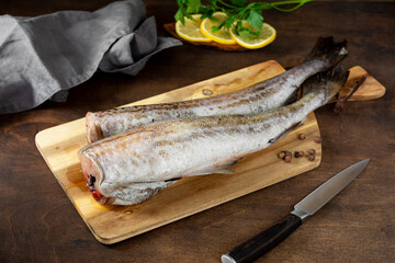 Pollock fish. Pollock on a chopping Board on a brown kitchen table. Preparation for cooking fish