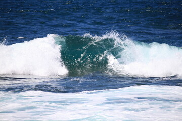 Big breaking ocean wave on a sandy beach