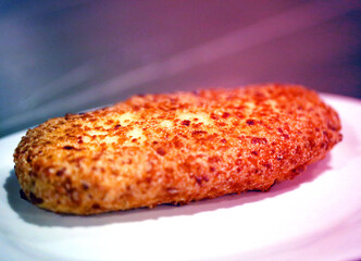 Photo of delicious cheese cutlet in bread crumbs on a plate