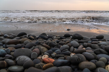 Fototapeta na wymiar Pebbles on beach washed by waves at stormy weather