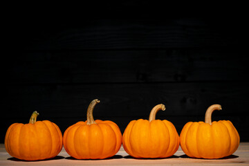 Yellow pumpkin on wooden black background. Halloween concept. Copy space