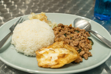 Thai local food, gapao rice, rice served with minced chicken or pork, comes with fried egg.
