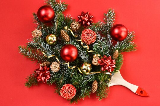 Creative composition Christmas and New year. Paint brush with Christmas fir and ornaments on a red background. Minimal New Year background decoration concept. Flat lay. Copy space. New Year card. 
