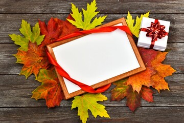 Naklejka na ściany i meble Teachers day. Autumn composition. Workspace with blank notebook, gift box with red ribbon and red maple leaves. Copy space.Top view, flat lay. Autumn concept. Greeting card.