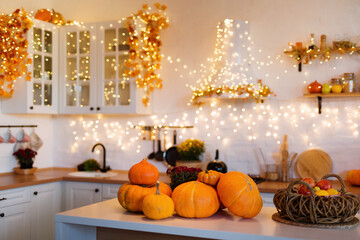 Autumn kitchen interior. Red and yellow leaves and flowers in the vase and pumpkin on light background