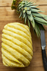 Ripe perfectly peeled pineapple, on a wooden background.
