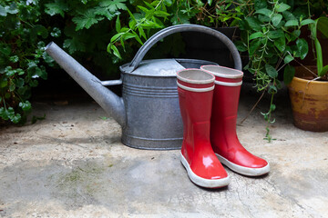 bottes rouges et arrosoir sous la pluie © Sophie Animes