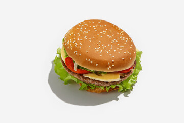 Delicious fast food and snack for lunch takeaway during covid-19 pandemic. Yummy big cheeseburger with tomatoes and salad with shadow