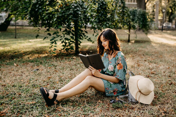 Young woman in a park reading a book.