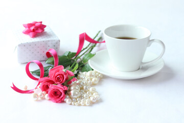 ホットピンクのバラの花束とパールと贈り物とコーヒー