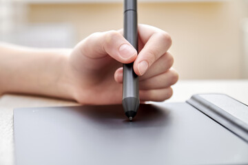 Girl draws on a graphics tablet with pen. Close-up, selective focus