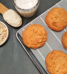 Freshly baked oatmeal  cookies on cooling rack over gray wood